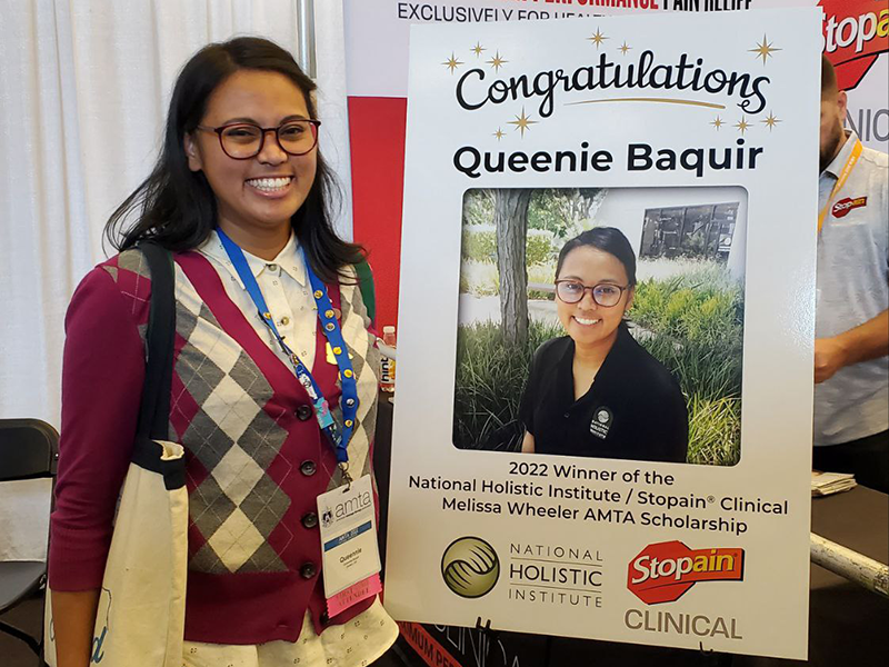 NHI Santa Ana graduate Queennie Baquir with her congratulatory poster at the 2022 AMTA National Convention