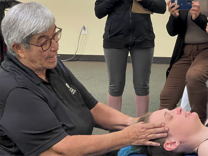 Cynthia Ribeiro demonstrates neuromuscular therapy bodywork during a CE massage class